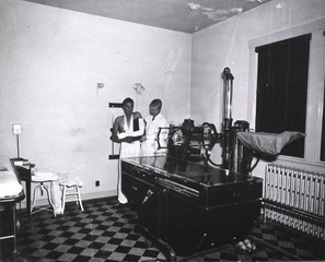 Indian Hospital, Sante Fe, New Mexico: X-ray room. Technician, Mr. Wilson, prepares to x-ray arm of young patient