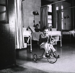 Middlesex Hospital, London, England: Blue baby rides tricycle after operation