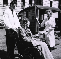 Middlesex Hospital, London, England: Patient being taken in wheel chair to ambulance