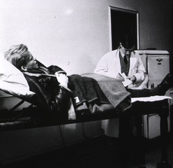 Middlesex Hospital, London, England: Casualty receiving room with surgical officer examining patient