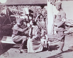 [Medical officer examining the throat of a French civilian]