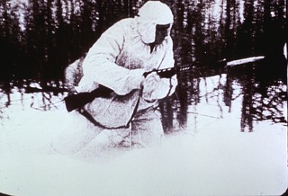 Military: Field Medical Services: View showing Soviet soldier in winter camouflage suit with Tokarev rifle and bayonet