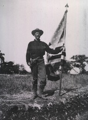 Color Sergeant Riley Porter, in the trenches before Santiago, July 9/98. (The flag has three bullet holes)