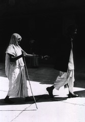 [Man leading blind woman in India]