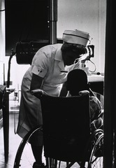 [A nurse is attending to a child in a wheelchair]