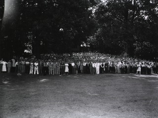 [PHS ceremony on lawn near Building 15K, employees(?) gathered for group photo, Bg.15k in background]
