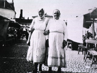 [Two women at an outdoor market]