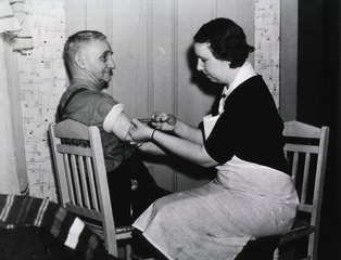 [Nurse giving an old man an injection.]
