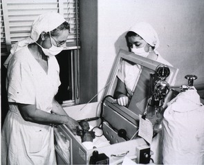 [Nurses with premature baby in an incubator]