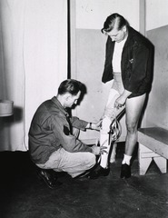 [A young man being fitted with a prosthetic leg]