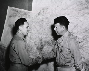 Colonel Perrin A. [sic] Long, Medical Corps, receives congratulations from Col. Earle Standlee, Chief Surgeon, MTOUSA, after being presented with the Legion of Merit