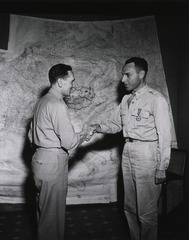 Colonel Earle Standlee, Chief Surgeon, MTOUSA, congratulates Col. Albert A. Biederman, Minneapolis, Minn., after presenting him with the Legion of Merit