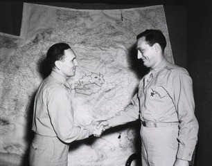 Colonel Earl [sic] Standlee, Chief Surgeon, MTOUSA, congratulates Capt. Peter J. Germanic, Centerville, Iowa, after presenting him with the Bronze Star Medal