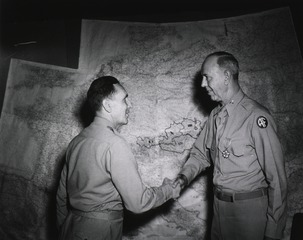 Colonel Earle Standlee, Chief Surgeon, MTOUSA, congratulates Col. James E. Noonan, Washington, D.C., after presenting him with the Legion of Merit