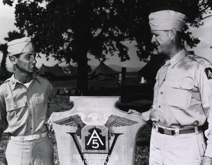 Captain Leslie J. Weil of the 549th Medical Ambulance Company, left, accepts the U.S. Fifth Army plaque awarded his company for services performed at Anzio in evacuating hospital ships