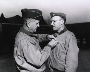 Brigadier General Joseph I. Martin, 2nd Auxiliary Surgical Group, awards the Legion of Merit to Maj. Reeve H. Betts, 51 Devon Road, Newton Center, Mass., Fifth Army, Lucca Area, Italy, 14 February 1945