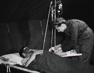 [Nurse administers intravenous fluid to a wounded American soldier somewhere in France]