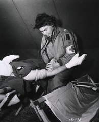[Army Nurse takes blood pressure reading of patient]