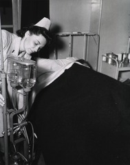 [Army Nurse prepares intravenous injection for patient]