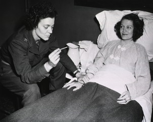 [Army Nurse checks temperature of patient]