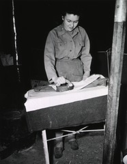[Army Nurse uses an old-fashioned set of flat irons]