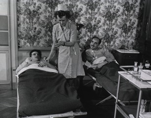 [Army Nurse 2nd Lt. Margaret Edwards checks pulse of a patient]