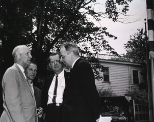 [Secretary Fleming speaking with three NLM supporters at the groundbreaking ceremony]