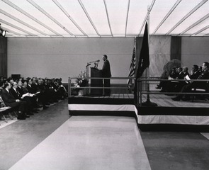 [Dr. Daniels standing at the podium during the dedication ceremony]