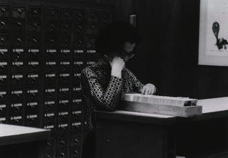[Searching the card catalog in the rotunda]