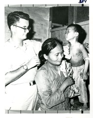 [Dr. Mackler swabs the chest of a Vietnamese boy held by his mother]