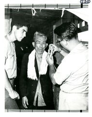 Dr. Mackler examines the finger of an elderly Vietnamese man