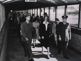 [Passengers arriving from Paris at LaGuardia Airport in New York City and walking through the walk-way, known as the "sheep run," to the quarantine room]