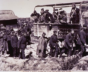 Truckload of slightly wounded men of the 79th Division watch German prisoners pass by near Malancourt, September 28, 1918