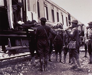 Carrying wounded men aboard a hospital train at Horreville, April 27, 1918