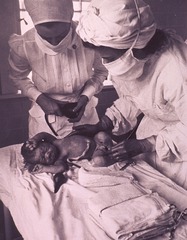 [Nurses cleaning a newborn]