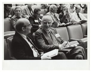 Francis Crick and Arthur Kornberg seated in the audience at a scientific symposium at the Stanford University School of Medicine