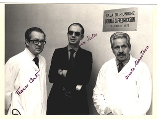 Franco Conti, Cesare Sirtori, and Oreste Mantero standing in the Donald S. Fredrickson Meeting Room at the Maggiore Hospital in Milan, Italy