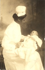[African American nurse holding a baby]