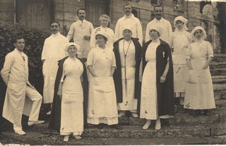 [Group of five men and seven women standing together]