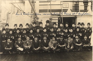 [Group of men and women sitting together in rows on the deck of a ship]