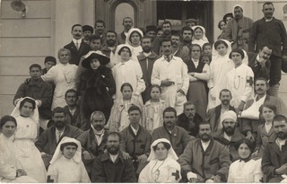 [Group of medical staff and patients outside of a building]