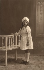 [Child dressed as a nurse with hand on bench]