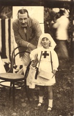 [Child dressed as a nurse holding hands with man]