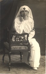 [Portrait of a nurse in white uniform sitting in a chair]