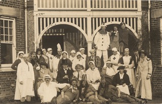 [Group photo of nurses, convalescing soldiers, and men in costumes]