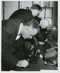 John E. Fogarty looking through a microscope