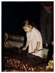 Olga DeBakey (age 3) playing native xylophone during Jakarta, Indonesia visit